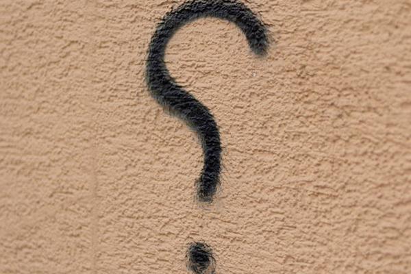 Question mark written on a wall.